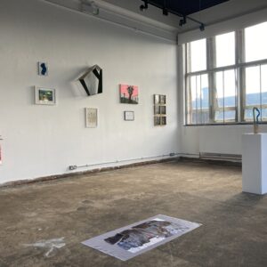 large room with white walls grey floor and art work