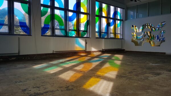 Large room with colourful vinyl shapes on window